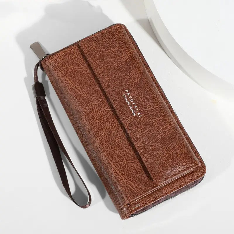 Men’s pu leather long wallet in brown textured leather with wrist strap and silver zipper pull.