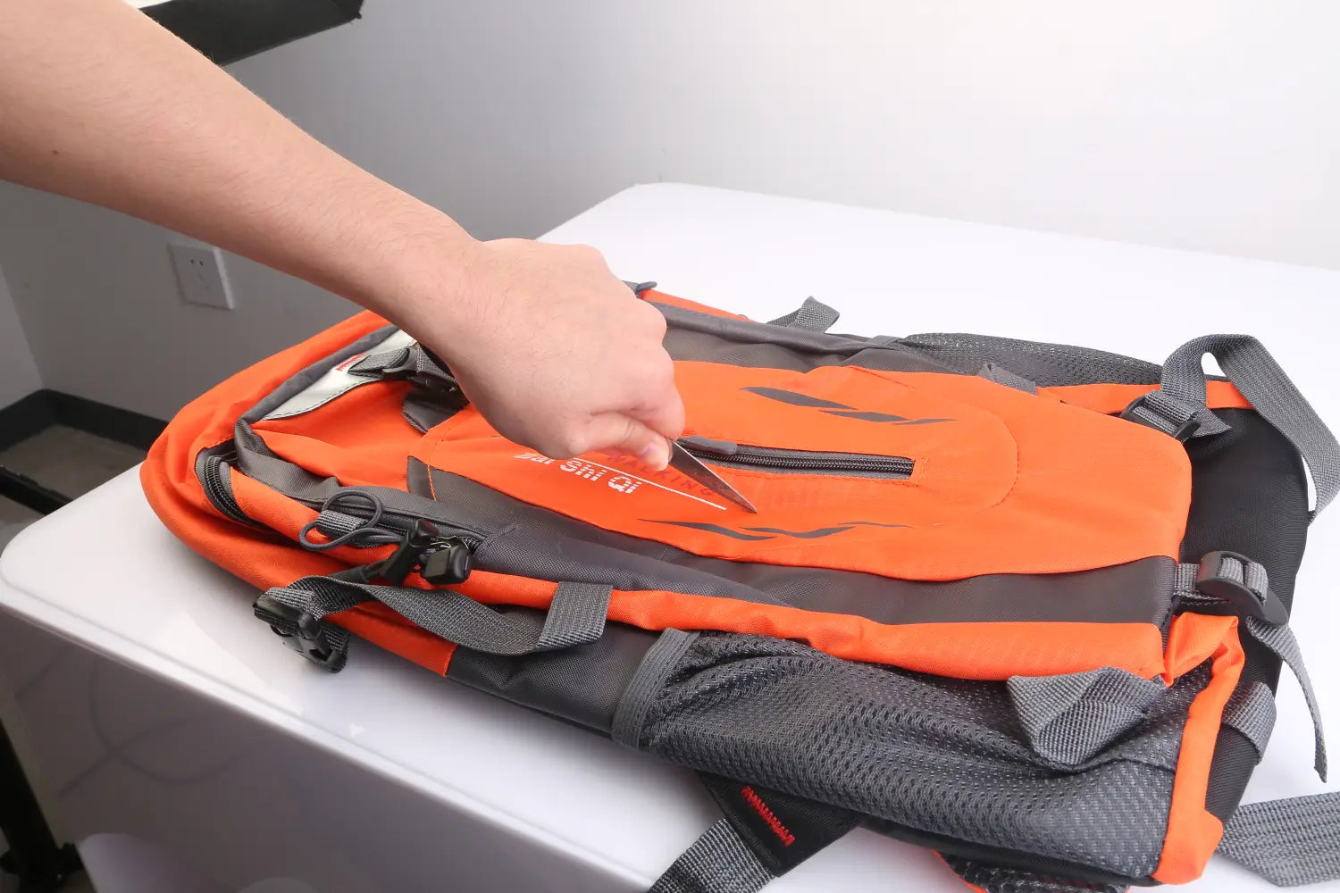 Orange and gray 36l lightweight waterproof hiking backpack with black zippers, mesh side pockets, and reflective stripes.