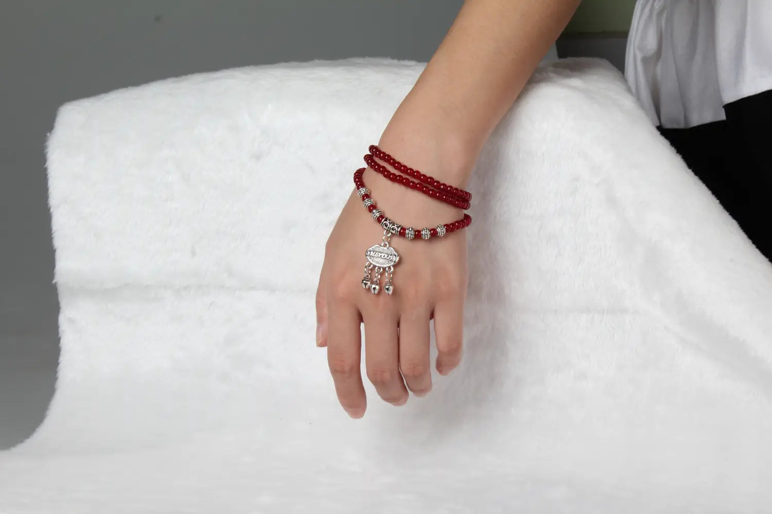 Red agate good luck bracelet featuring red beads silver-toned engraved protect charm and small bells.