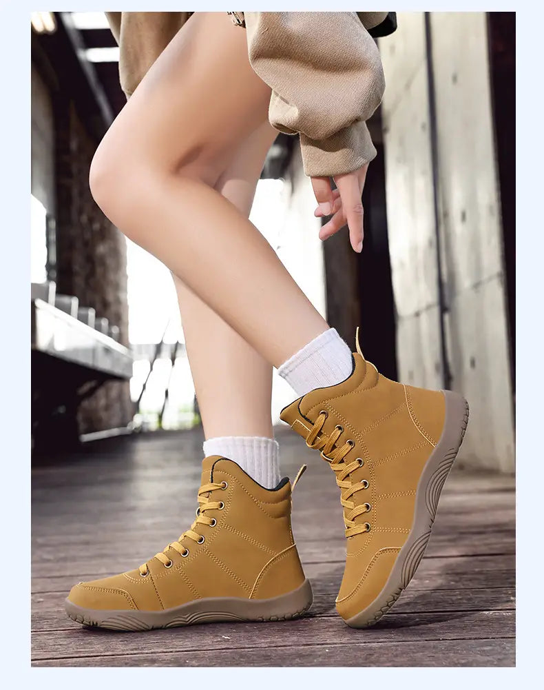 Hellbraune Wildleder-Wanderstiefel mit breiter Zehpartie und Leder-High-Top-Design als Sportschuhe, mit passenden Schnürsenkeln und einer robusten Gummisohle.