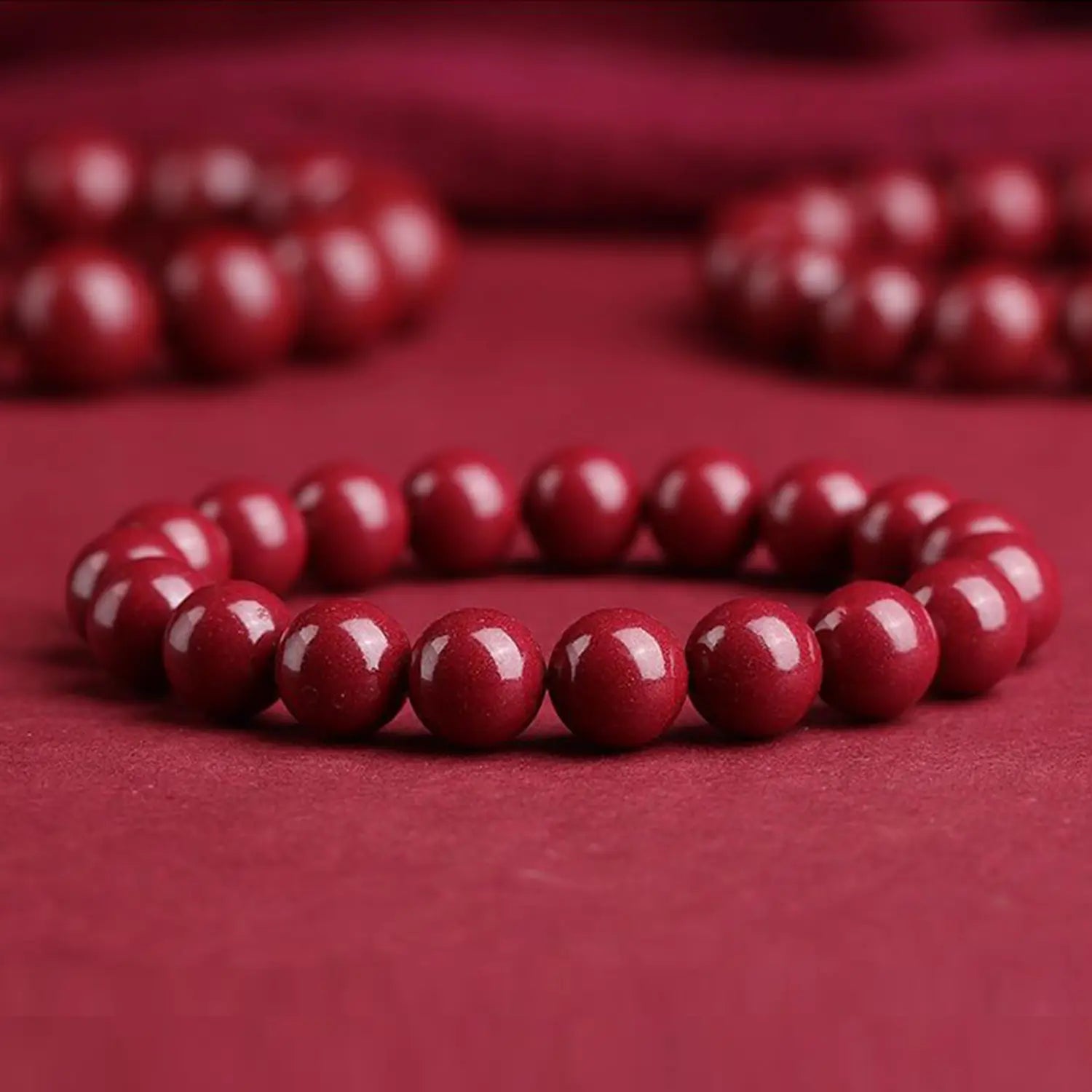 A polished red cinnabar spherical bead bracelet featuring smooth, uniformly sized deep red beads.