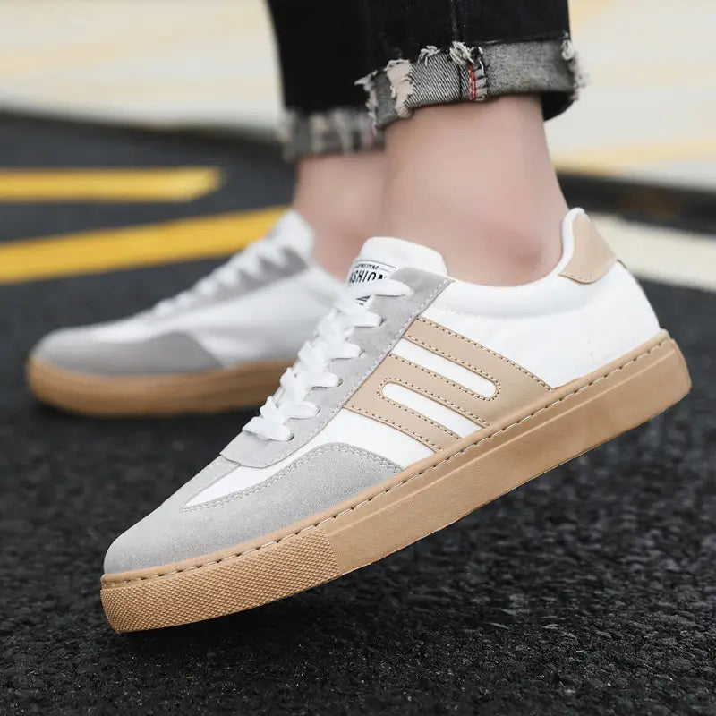 Chaussures de planche de mode décontractées en daim pour homme à tige basse, en blanc et gris, avec des semelles en caoutchouc beige et des finitions à rayures trois tons.