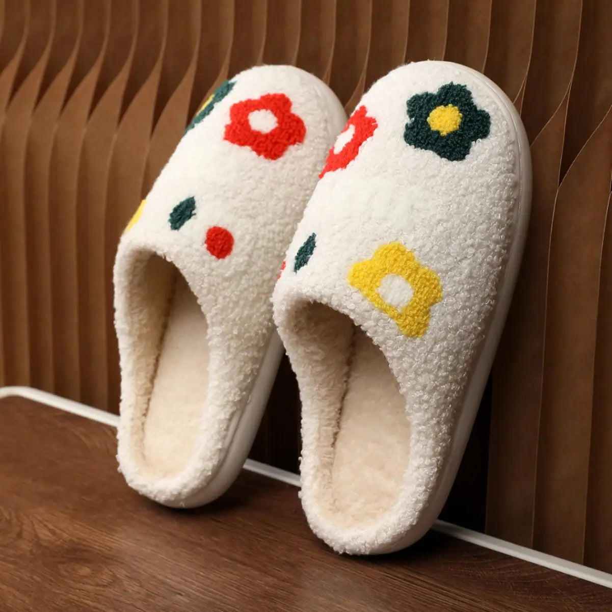 White fuzzy plush floral cotton slippers with colorful embroidered flowers in red yellow and green and soft tpr sole.