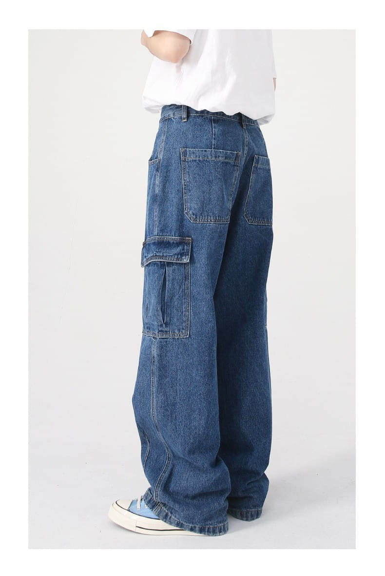 Blue denim cargo pants with large side pockets and a relaxed wide leg cut in a retro loose fit style.