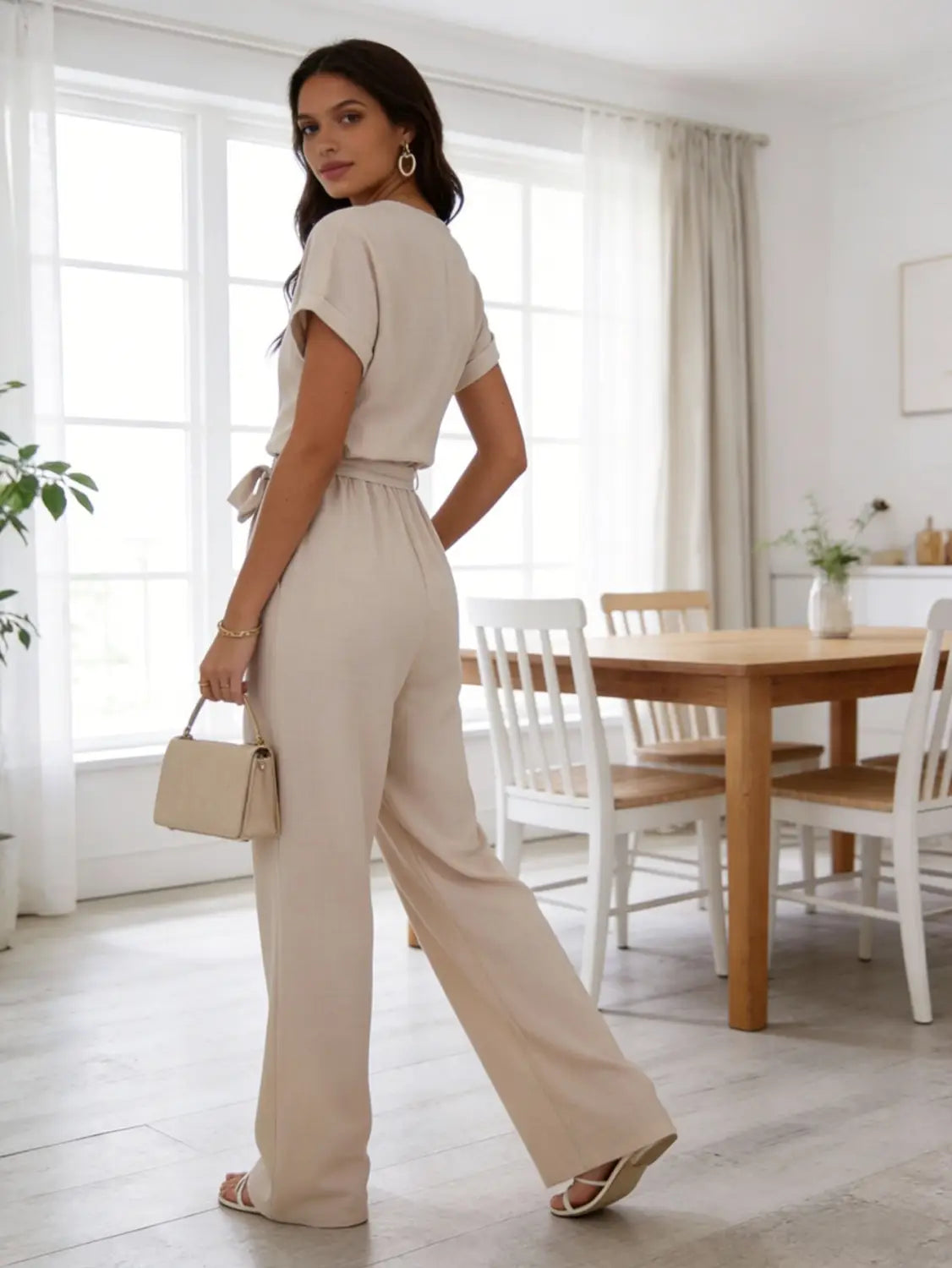 Mono de lino color beige con mangas cortas y cintura ceñida con cinturón, en un diseño de ajuste relajado.
