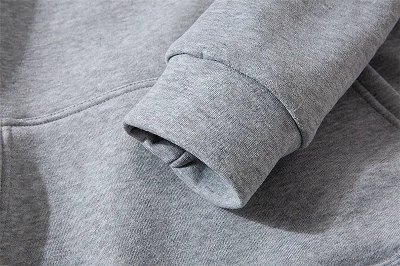 Manche de sweat-shirt chiné gris avec poignets côtelés sur un sweat à capuche de type pullover pour homme avec le visuel croisé « Philippiens 4:13 ».