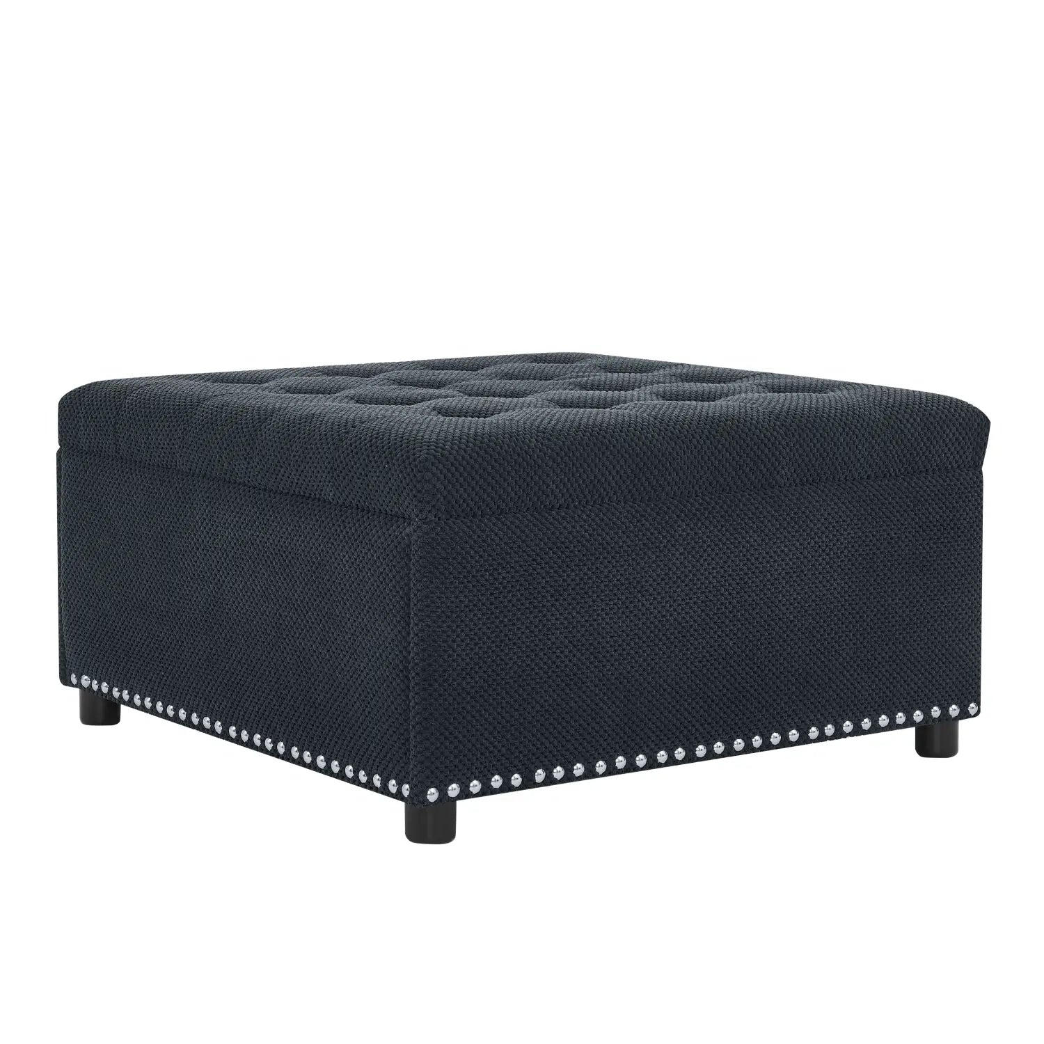 Black tufted storage ottoman in dark navy textured fabric with silver nailhead trim along the base.