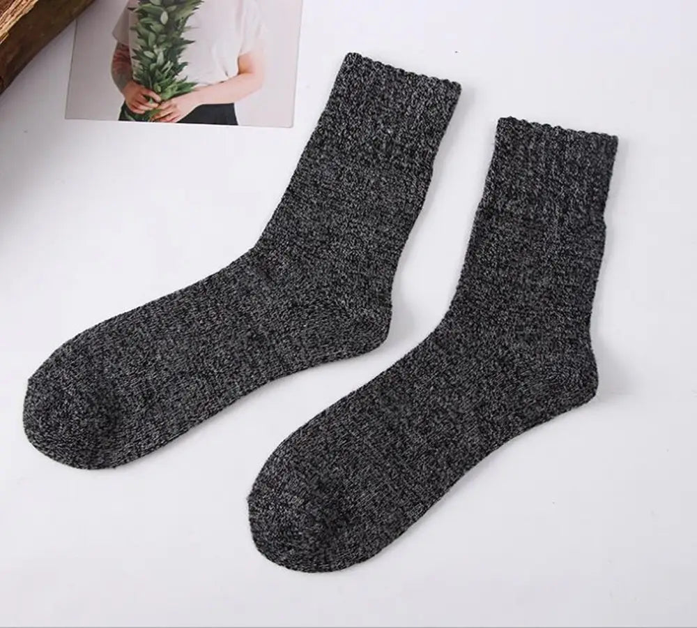 A pair of dark gray men’s rabbit fur winter socks featuring a textured knit design and ribbed cuff.