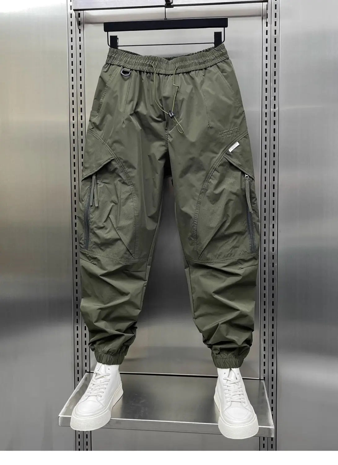 Men’s olive green tapered cargo joggers with elastic waistband drawstring and multiple side pockets.