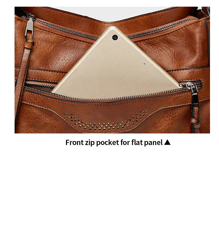 Braune Vintage-Ledertasche im Totebag-Stil mit vorderer Reißverschlusstasche, ausgelegt für flache Geräte, sowie mehreren Fächern für die Schultertaschen-Nutzung.