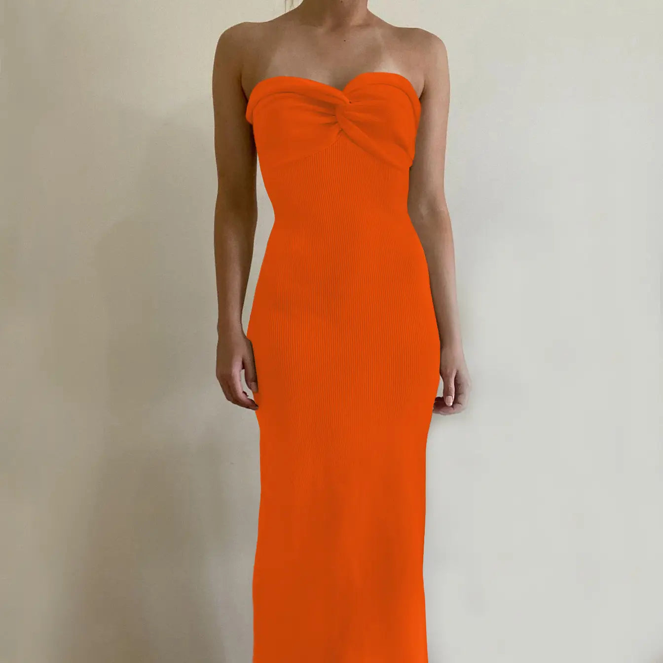 A vibrant orange off shoulder knotted ribbed knit midi dress with a strapless sweetheart neckline.