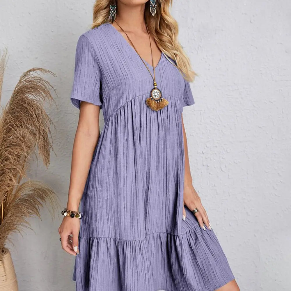 Une robe d’été à encolure en V pour femmes de couleur lilas, à manches courtes, en tissu léger.