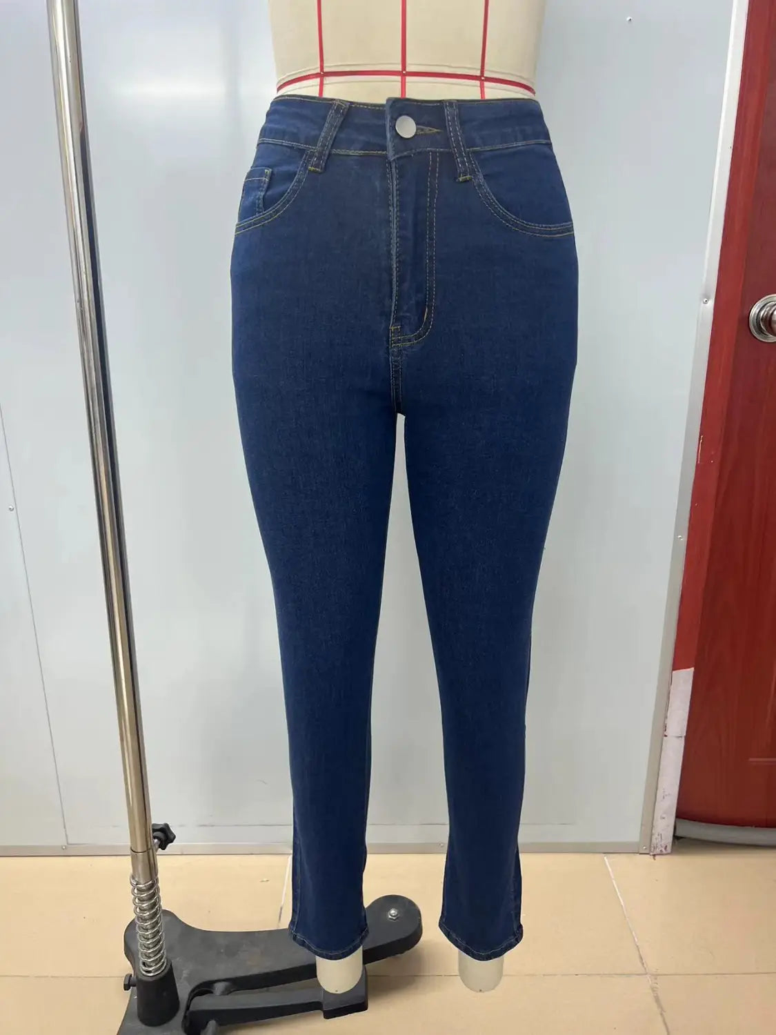 Leggings en jean bleu nuit à taille haute à coupe ajustée et coutures classiques, présentés du côté arrière.