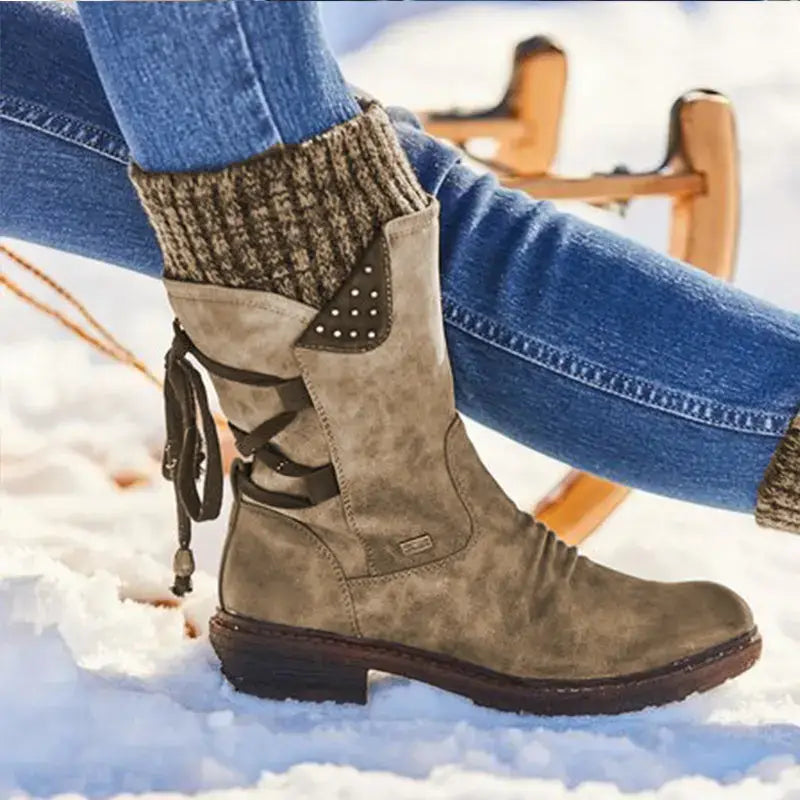 Women winter snow boots made of suede with dark brown laces and a decorative metallic stud panel, designed as mid calf martin shoes.