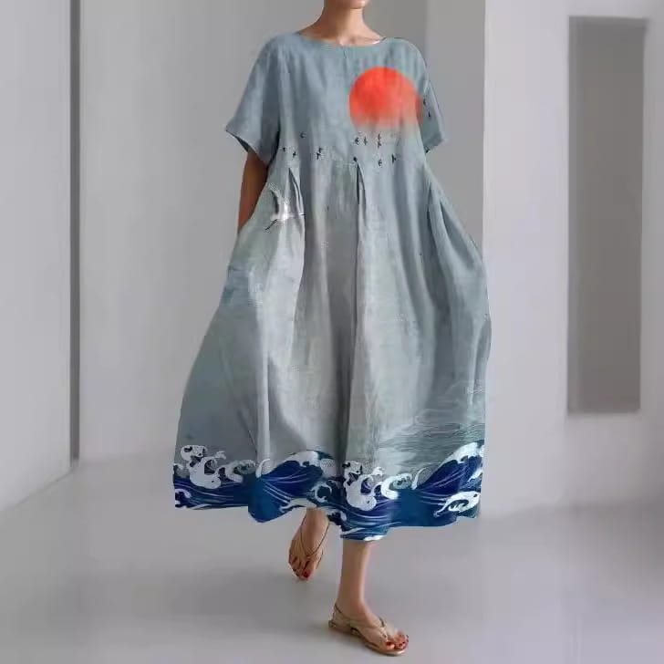 Robe longue en lin à imprimé floral grande taille à coupe A bleu clair, présentant un soleil orange vibrant et des motifs de vagues blanches.