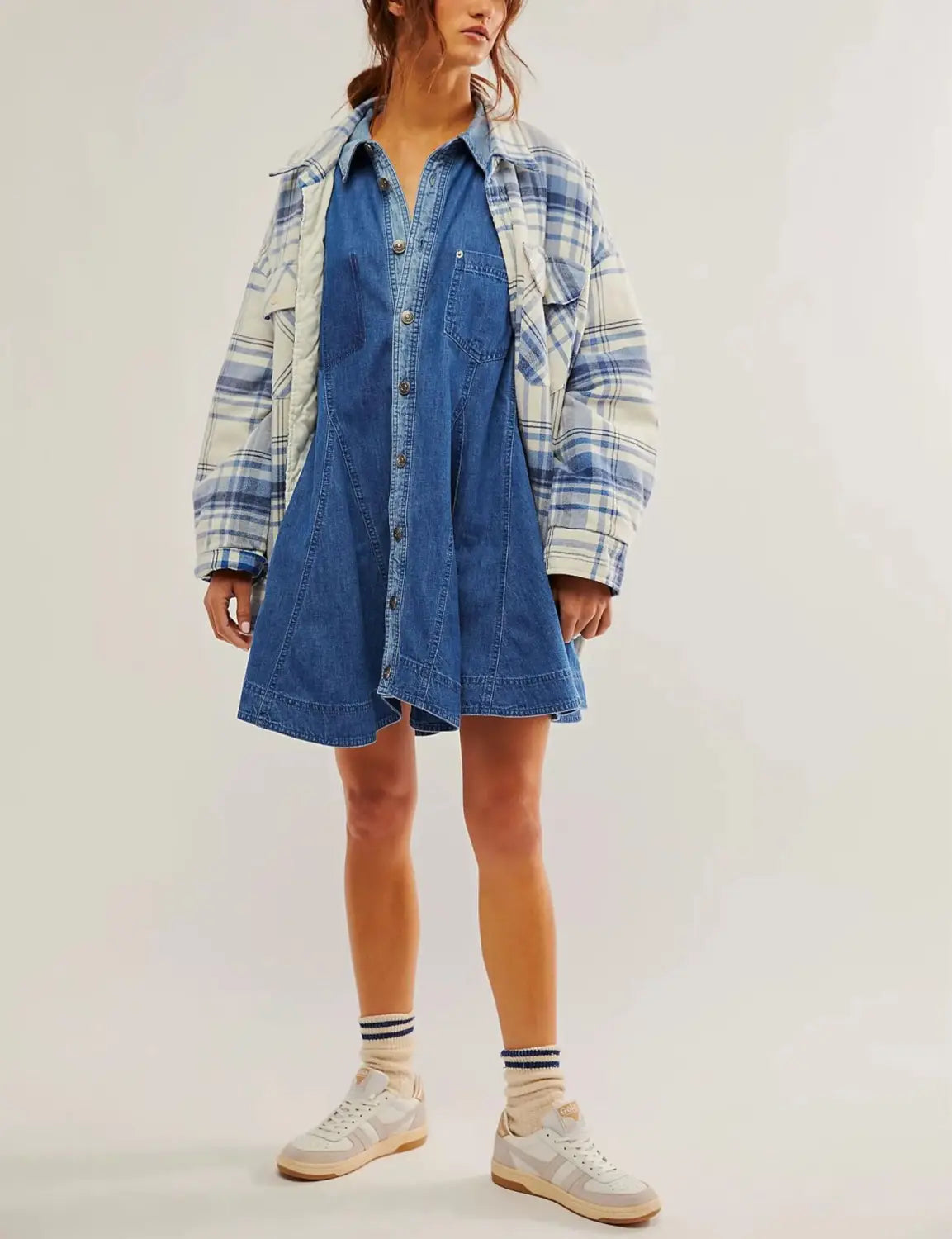 Blue denim lantern sleeve shirt dress with patch pockets layered under a plaid flannel jacket.