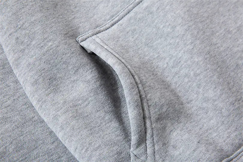 Sweat à capuche de type pullover pour homme avec le visuel croisé « Philippiens 4:13 » en molleton chiné gris, présentant une poche avant avec des coutures soigneusement réalisées.