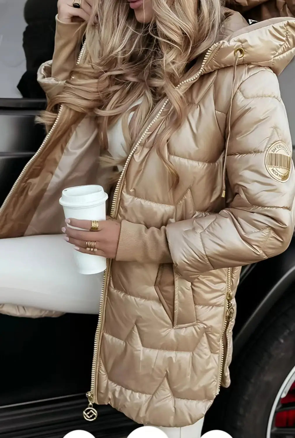 A shiny gold glossy hooded down puffer jacket with a quilted design and zippers along the front and sleeves.