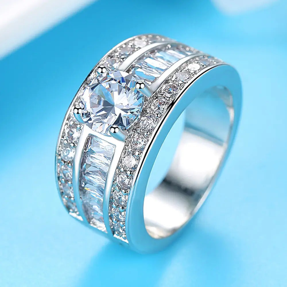 Silver band ring featuring a central round-cut clear zircon gemstone flanked by baguette and pavé-set stones in a vintage heart arrow adjustable silver ring design.