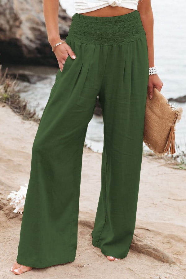 Green smocked wide leg pants for women featuring a high waist and elastic waistband in solid color.
