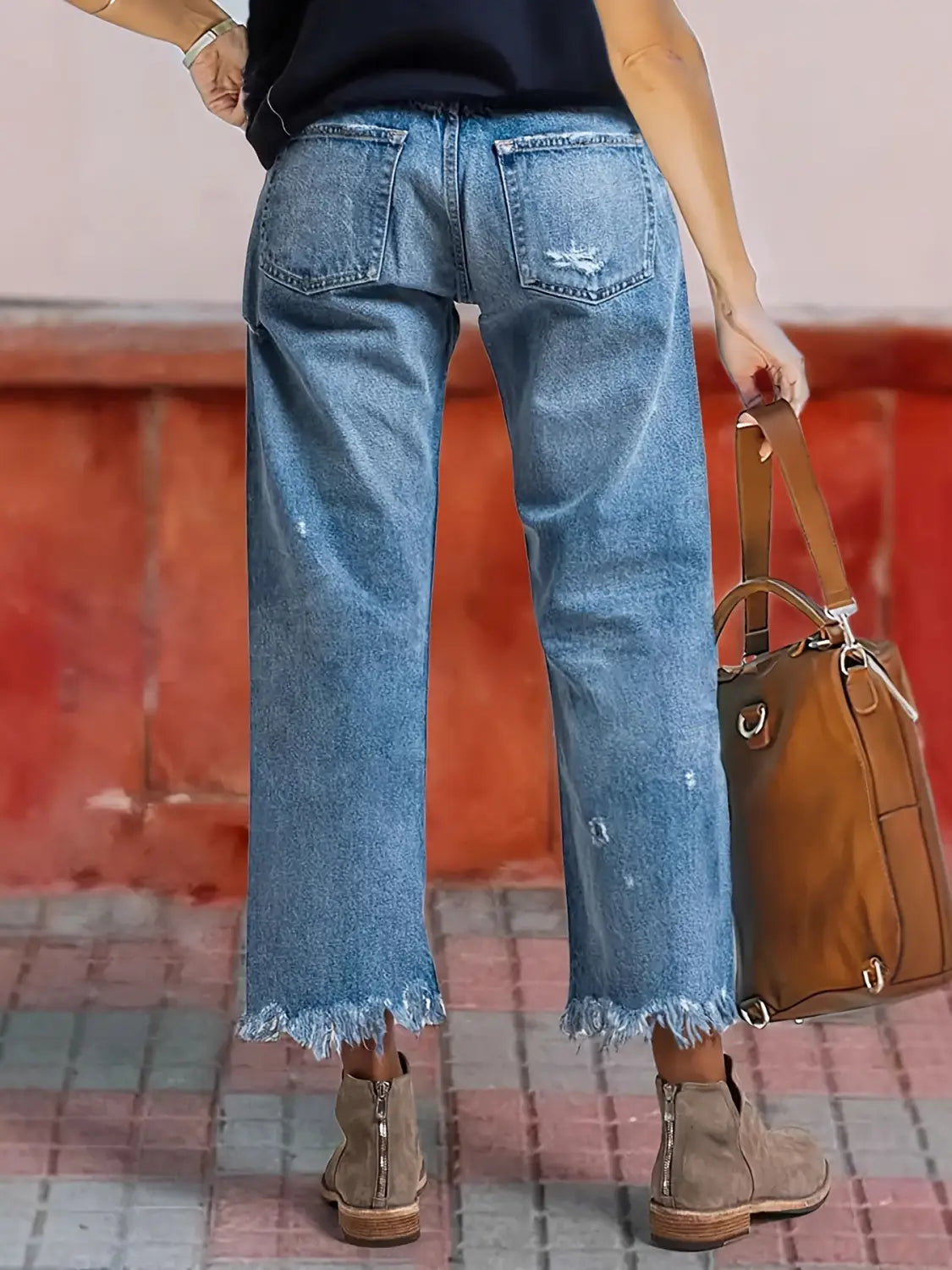 Jeans droits gris délavé déchirés confectionnés dans un denim à lavage clair, avec ourlets effilochés et aspect vieilli subtil.