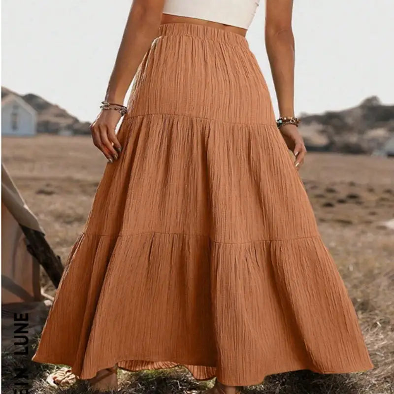 A flowing tiered maxi skirt in warm terracotta with a button front and lightweight textured fabric ideal for casual wear.