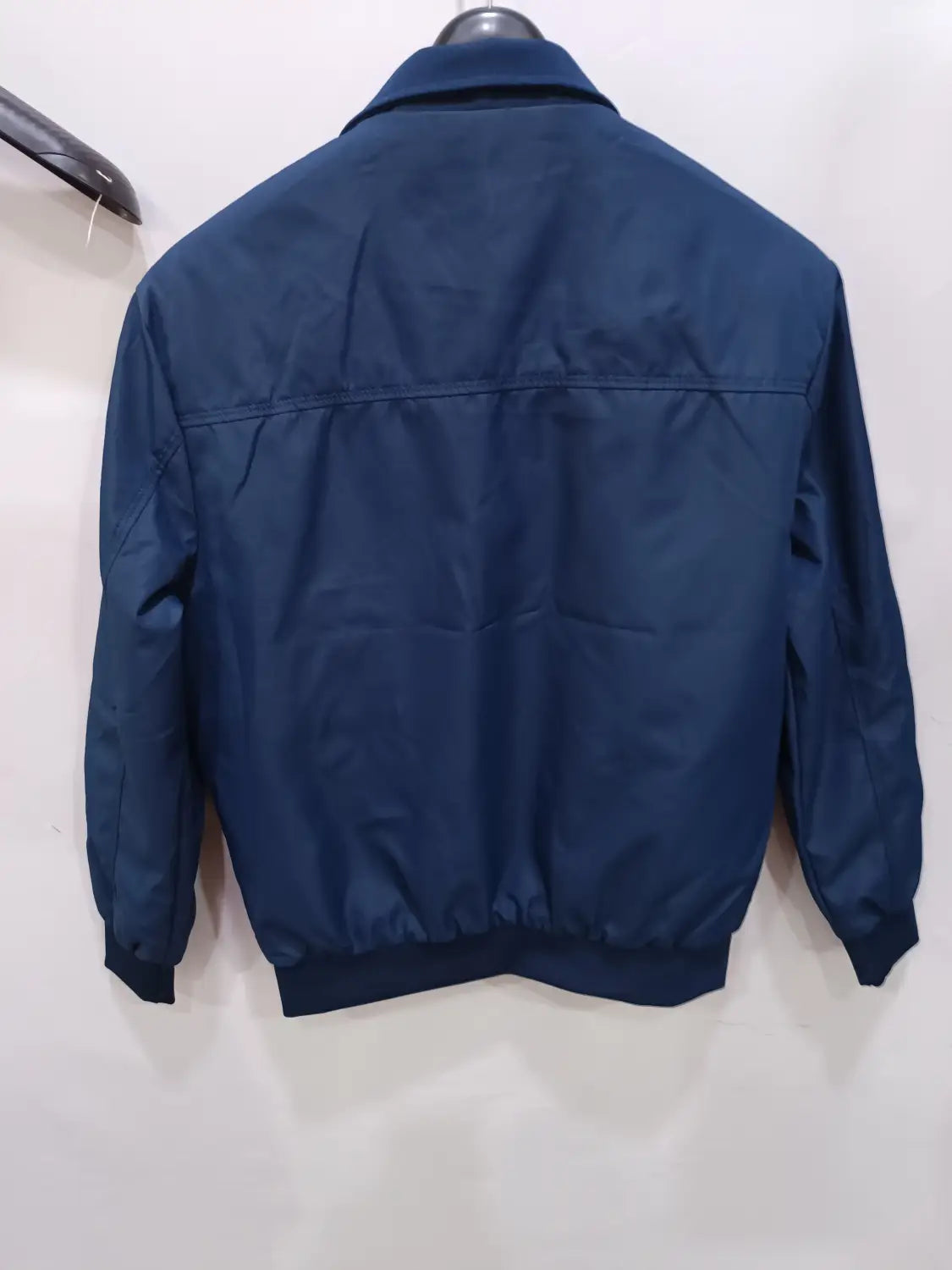 Veste bombardier légère pour homme en nylon bleu foncé, col classique, poignets côtelés, fermeture à glissière et doublure à carreaux.