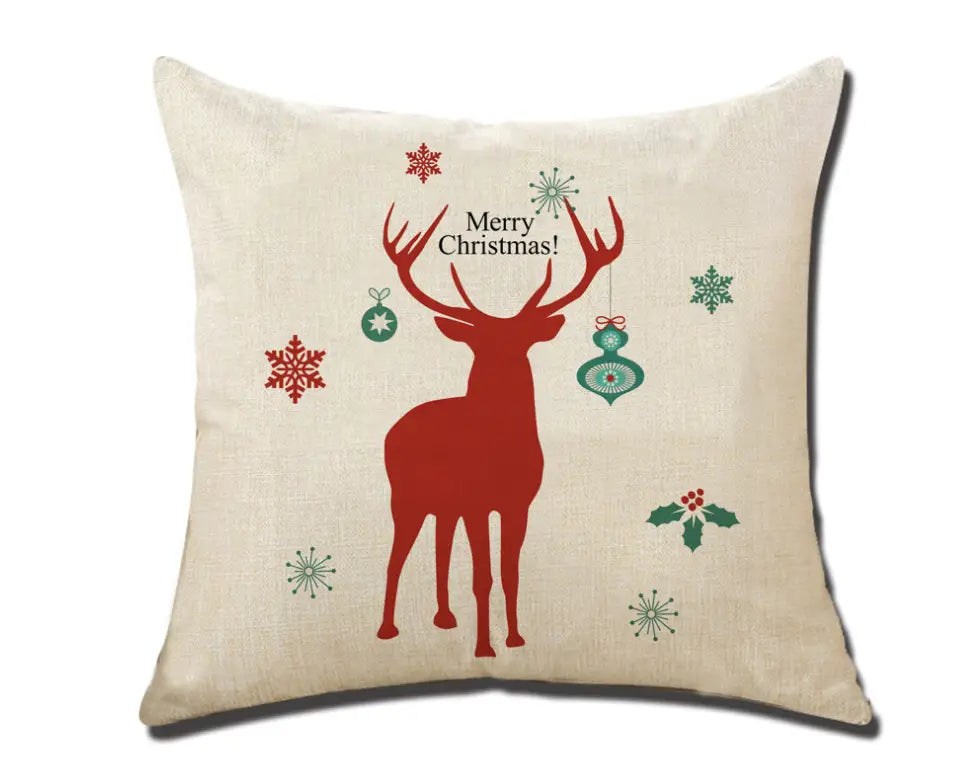 beige linen Christmas pillowcase featuring a bold red reindeer silhouette surrounded by green and red snowflakes, ornaments, and holly for festive holiday decor.