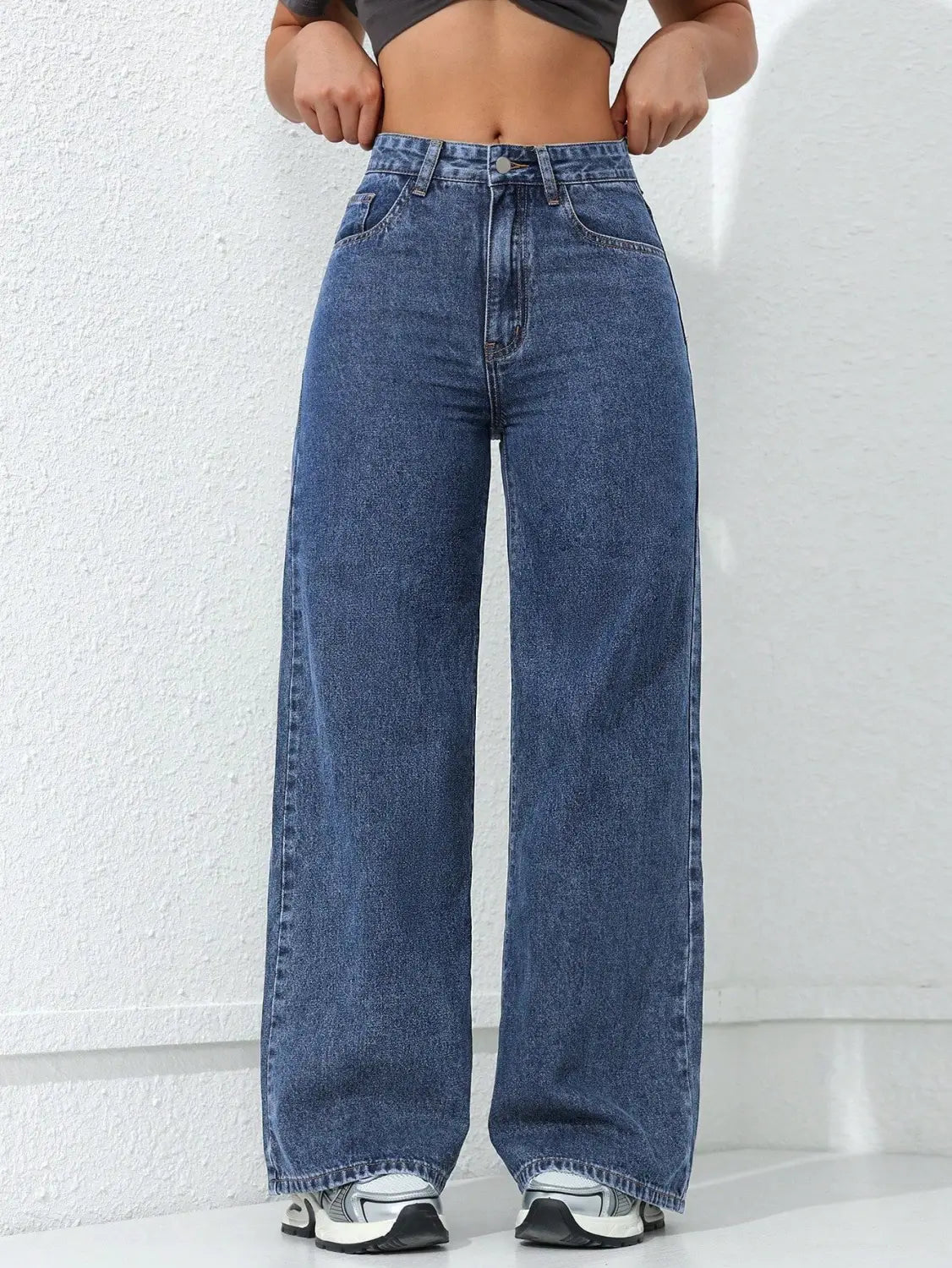 Jean à taille haute, jambe large et évasée, en tissu denim bleu, présentant un design classique à cinq poches