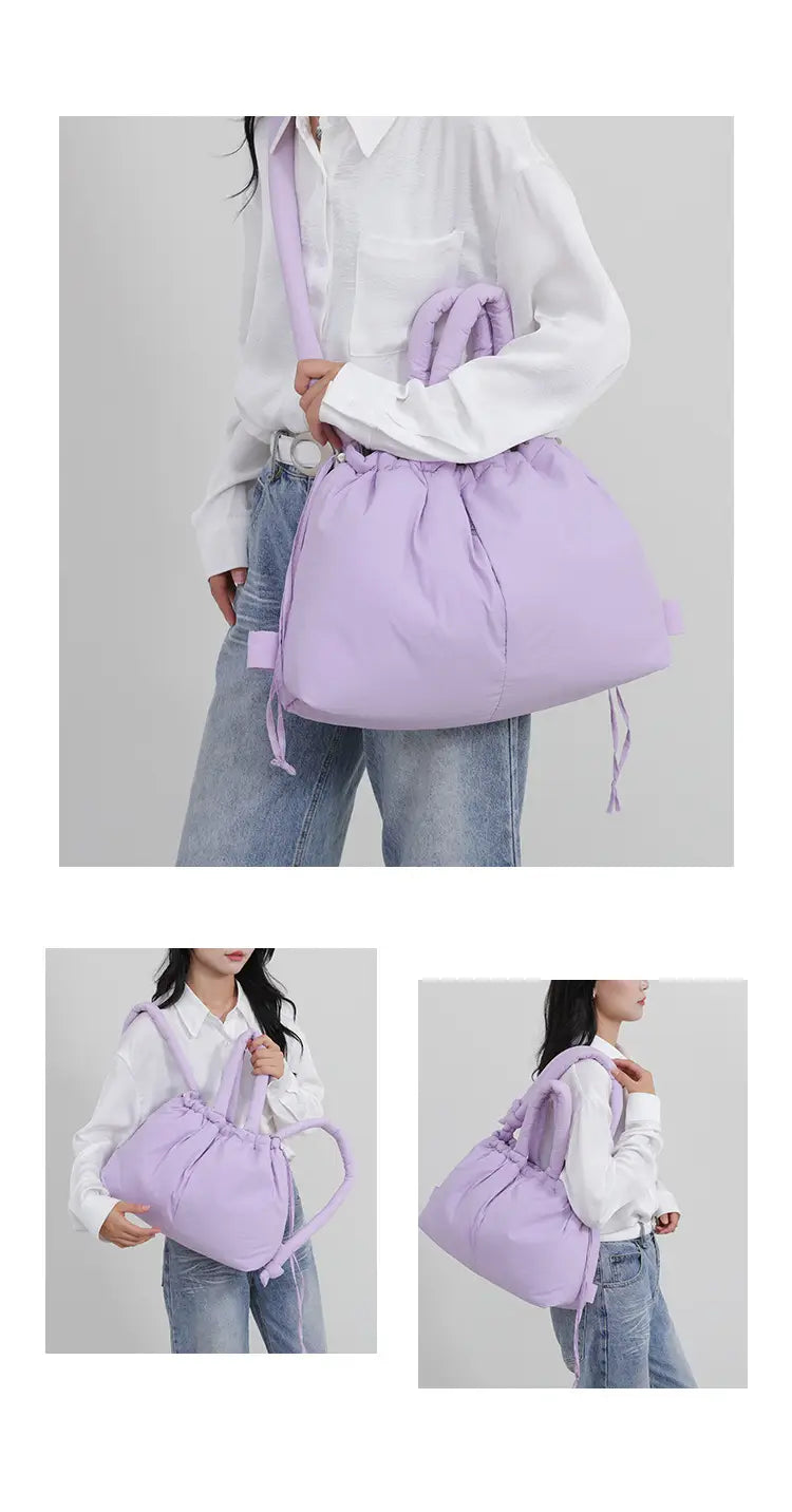 A soft lavender quilted puffer tote bag made of lightweight nylon with a structured yet relaxed silhouette, adjustable shoulder straps, and subtle fabric ties for closure.