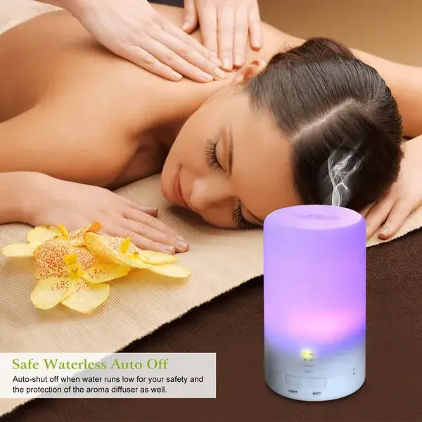 Purple and white cylindrical ultrasonic essential oil diffuser with a glowing base and 7 color LED lights for aromatherapy use.