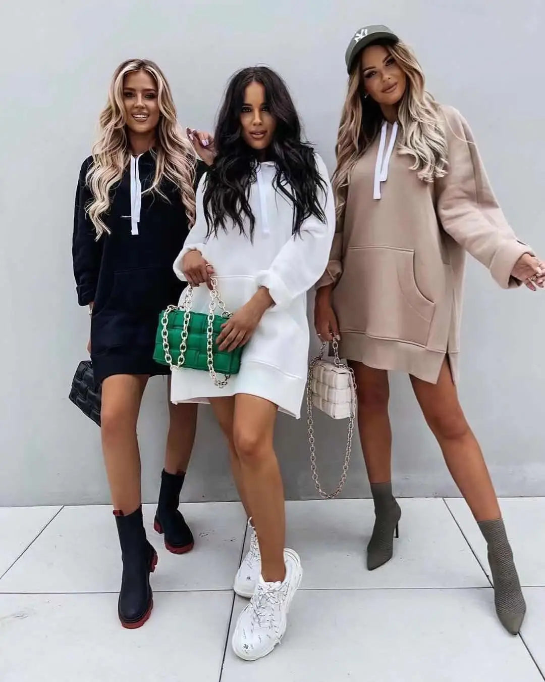 Green quilted leather chain strap handbag paired with oversized mid length hooded sweatshirt dress with pockets.
