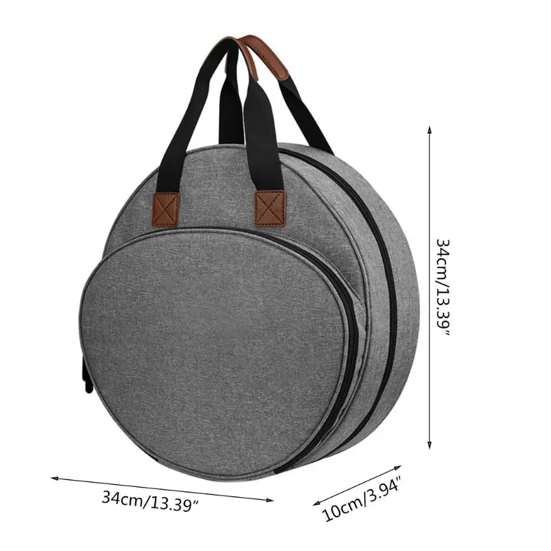 Gray circular guitar case with black zippers and brown leather accents on the handles featured as a premium circular embroidery and craft tool storage tote.