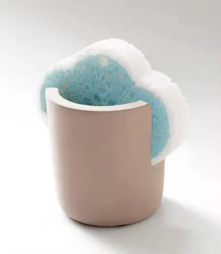 a soft beige ceramic diatom mud sponge rack kitchen sink caddy holder containing a blue and white textured porous sponge