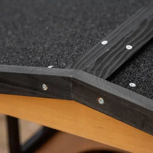 black wooden frame with textured surface secured by silver screws at joints on the back side of a wooden outdoor cat house multi level shelter