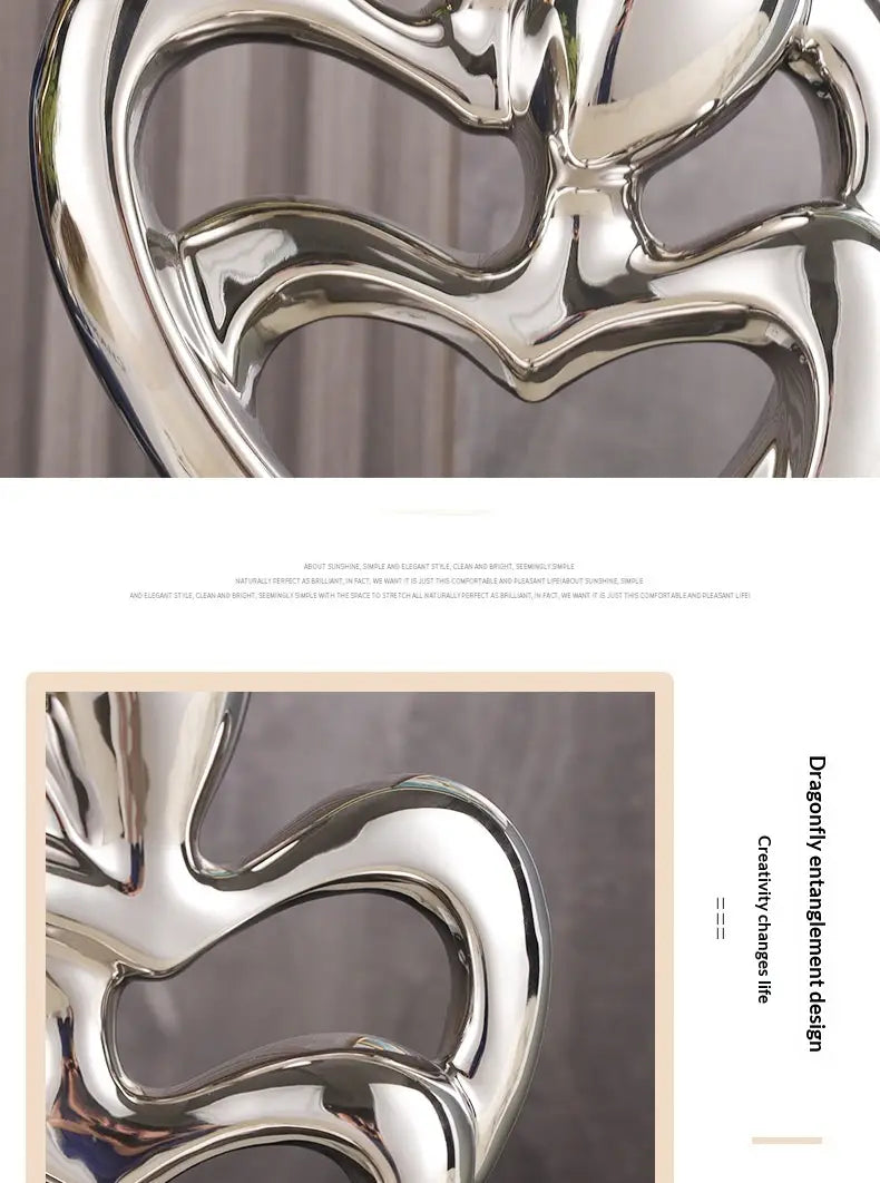 Shiny silver metallic abstract heart ceramic figurine with flowing intertwined curves designed as modern home decor.
