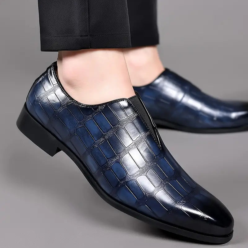 Deep blue crocodile-embossed leather men’s dress slip on loafers with a sleek polished finish and black rubber sole.
