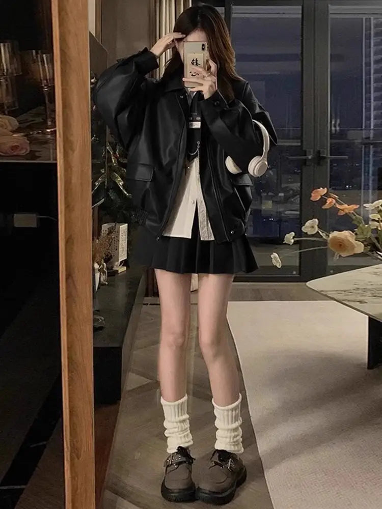 Black faux leather bomber jacket with oversized puffed sleeves and front pockets designed as a short coat.