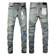 Men’s distressed slim fit patchwork denim jeans in blue with ripped knees and faded wash.