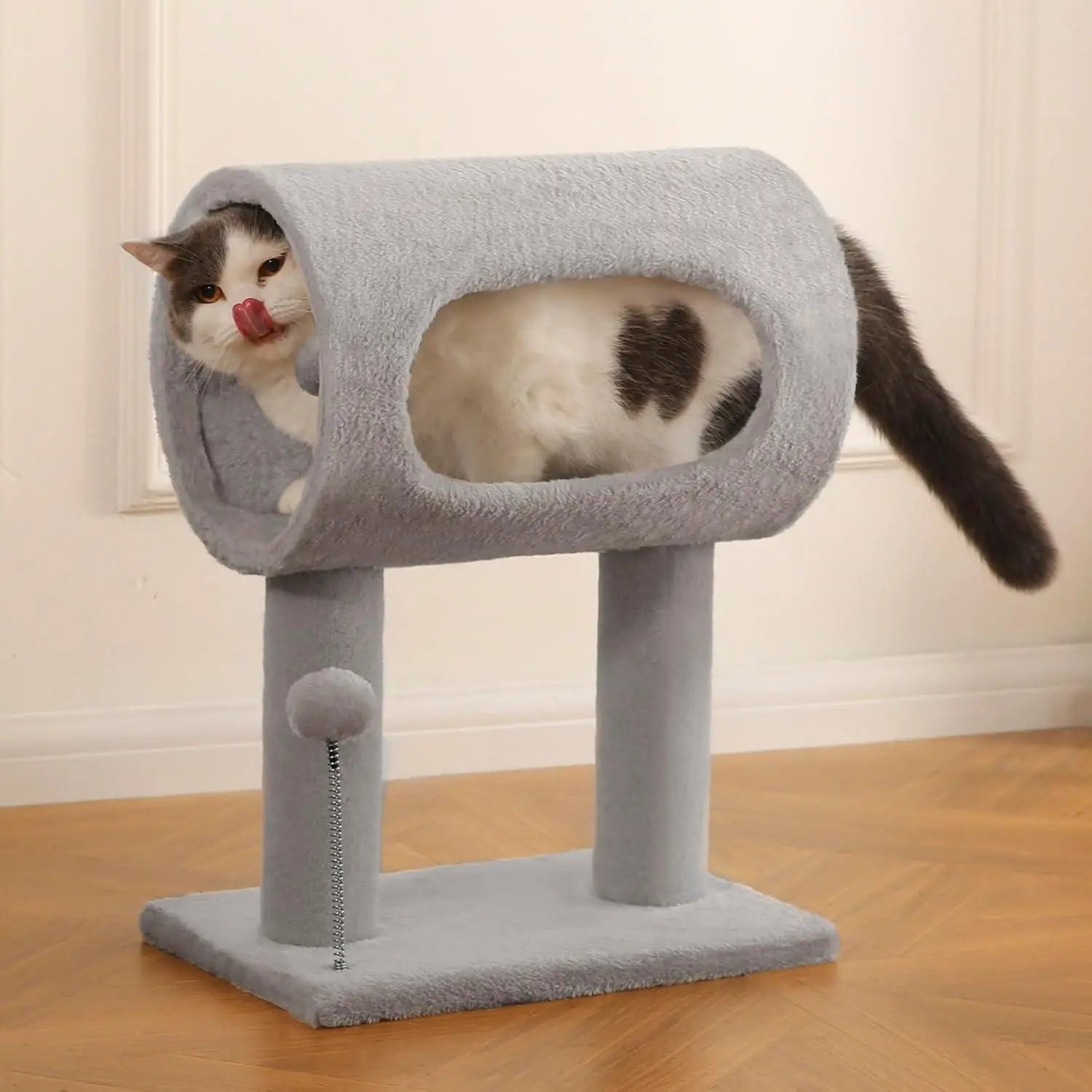 Gray plush cat tree with tunnel, scratching post, heart-shaped patch on the side, and a dangling pom-pom toy.