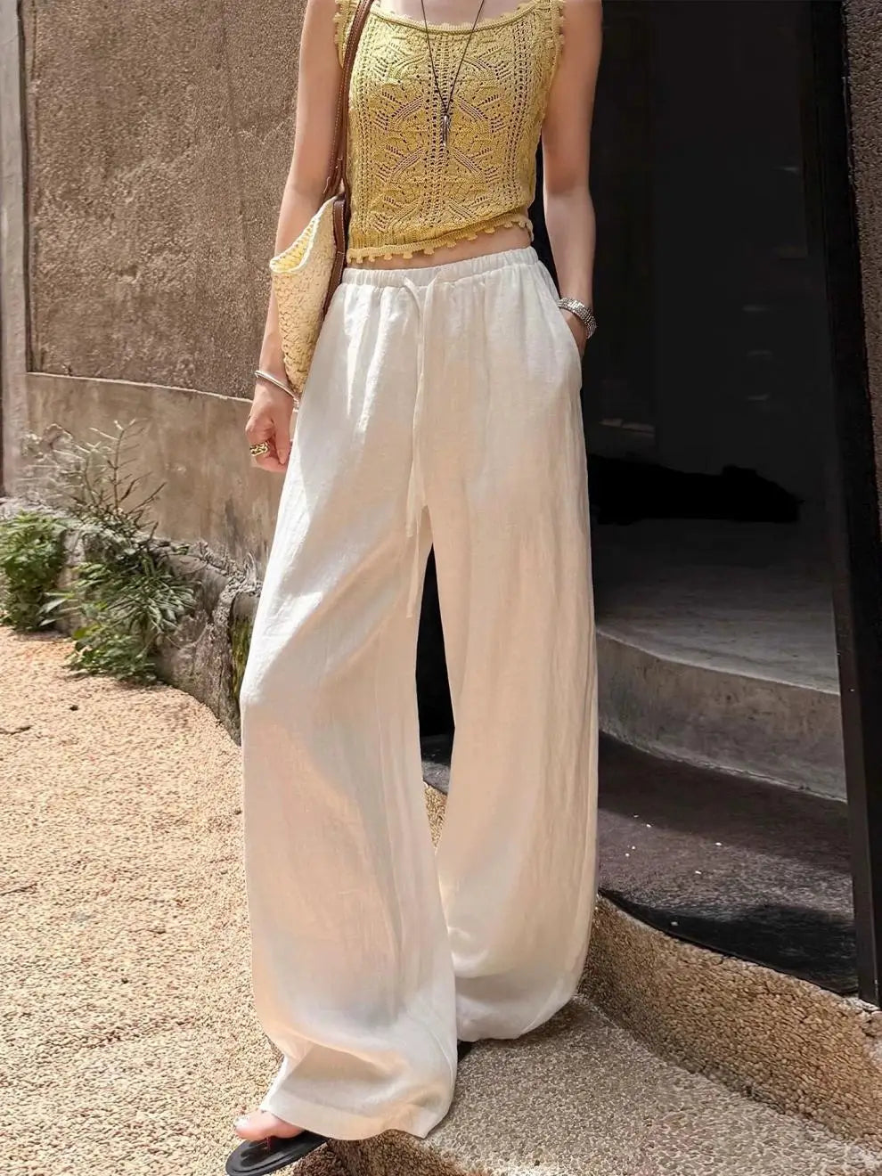 Pantalon ample en lin blanc à jambes larges avec ceinture à cordon pour un confort ajustable et une coupe décontractée.