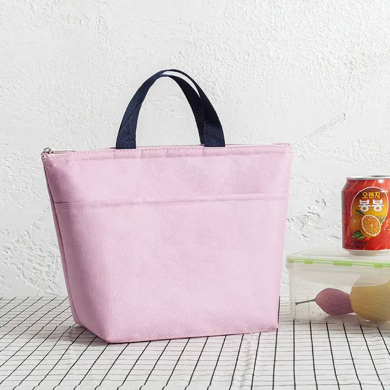 Isolierte Oxford-Bento-Lunchbag in Pink mit Reißverschlussverschluss und dunkelblauen Stoffgriffen aus strapazierfähigem Material.
