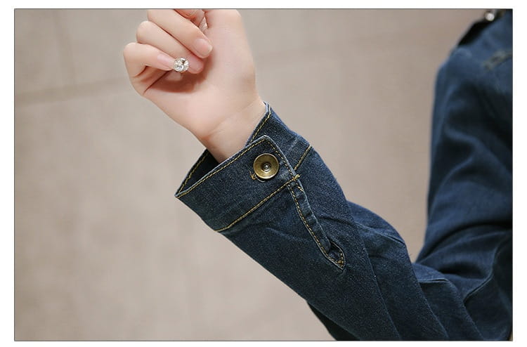 dark blue denim jacket sleeve with brass button and visible stitching featured as part of an elegant high waist button down denim midi dress