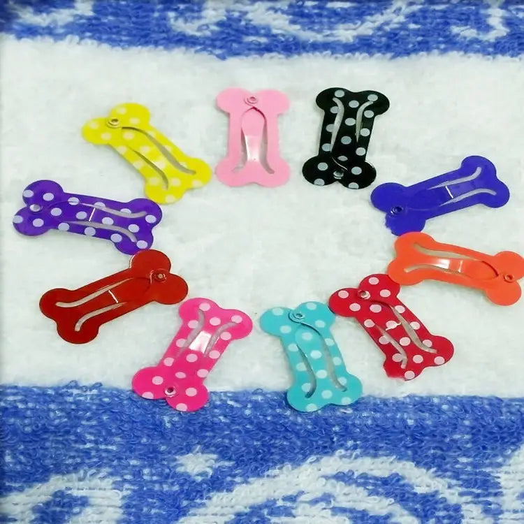 A set of colorful bone-shaped metal dog hair clips in various solid and polka-dot patterns for pet barrettes.