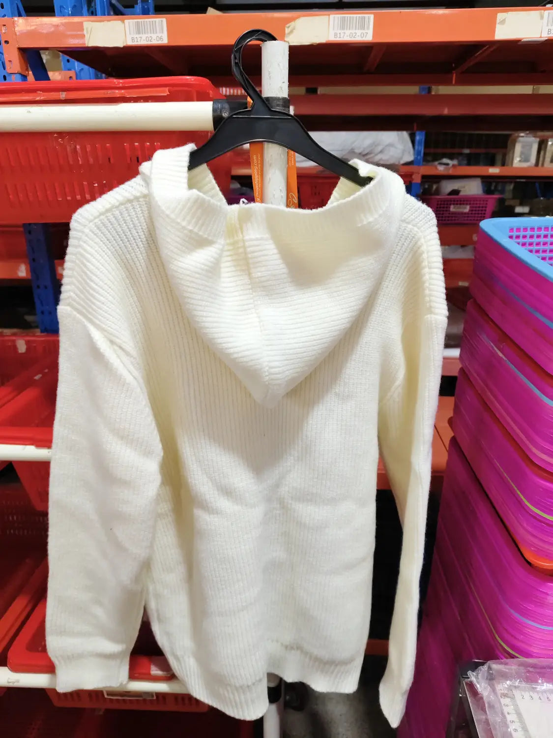 Ein cremefarbener Rippstrick-Hoodie mit gemütlicher, leicht übergroßer Passform, als Kapuzenstrickcardigan im Casual-Stil präsentiert.