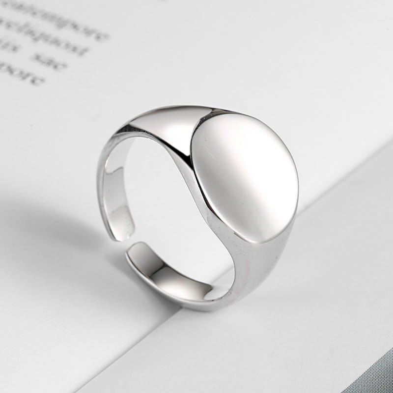 Silver adjustable oval minimalist signet ring with a smooth face and polished metallic band.