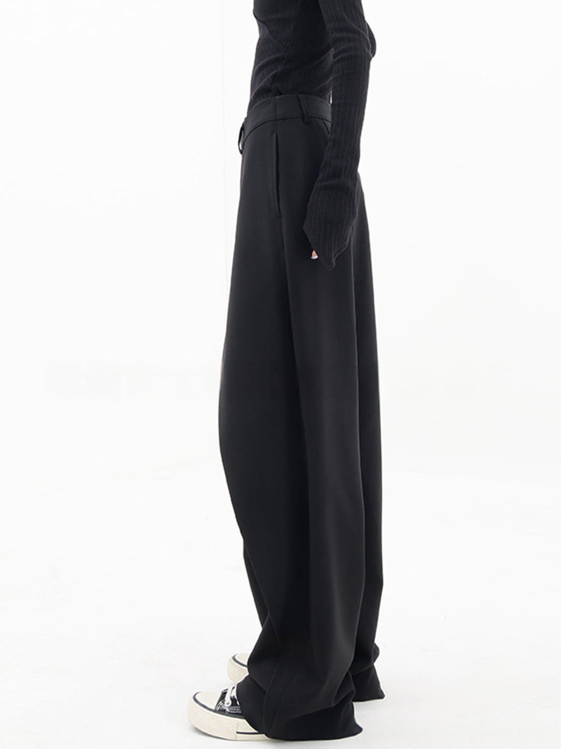 Schwarze asymmetrische Weitbein-Hosen mit einem eleganten minimalistischen Design und dezenten Falten am Bund.