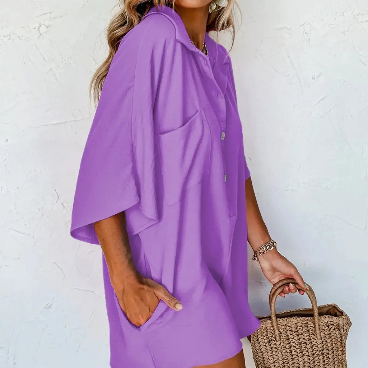 A flowing lavender button-up summer jumpsuit with a relaxed fit and short wide sleeves.