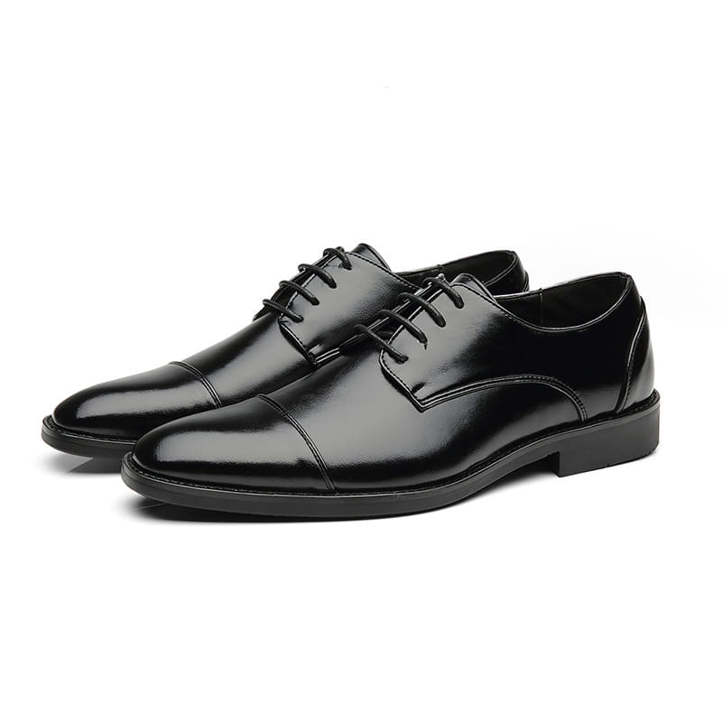 Herren-Businessschuhe im britischen Stil mit spitz zulaufender Zehenpartie aus schwarzem Kunstleder mit Lackoptik, mit klassischem Kappenzehen-Design und polierter Oberfläche.