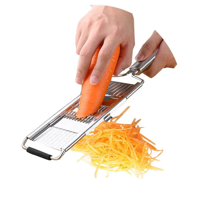 Juego de rallador y cortador multiusos de acero inoxidable plateado con superficie brillante de acero inoxidable y asa de agarre de goma negra; tritura una zanahoria naranja en hebras finas.